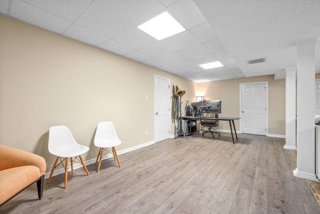 office area with light hardwood / wood-style flooring and a drop ceiling