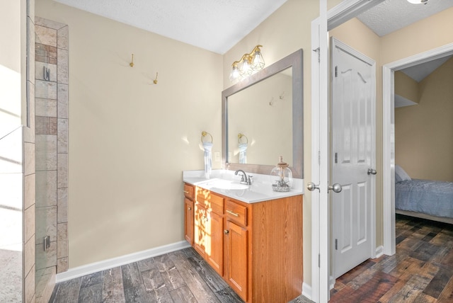 bathroom with vanity, hardwood / wood-style floors, a textured ceiling, and an enclosed shower