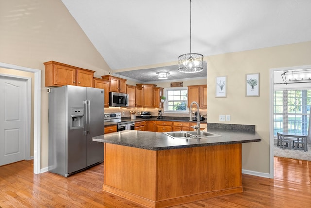 kitchen featuring sink, a chandelier, hanging light fixtures, kitchen peninsula, and stainless steel appliances