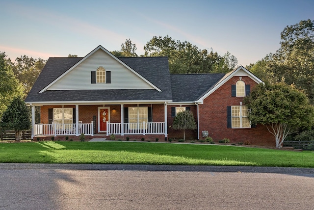 view of front facade with a porch and a lawn