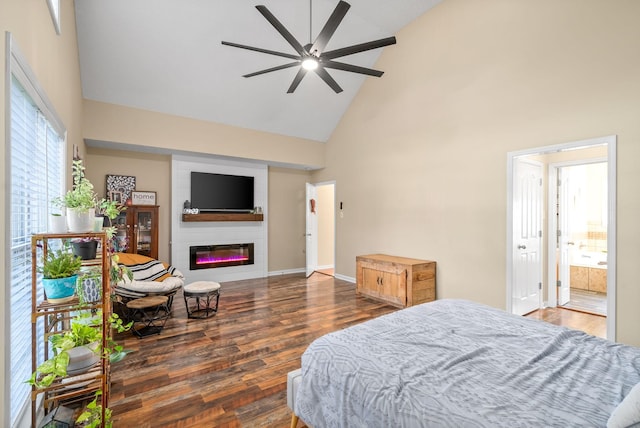 bedroom featuring ensuite bathroom, high vaulted ceiling, a large fireplace, and dark hardwood / wood-style flooring