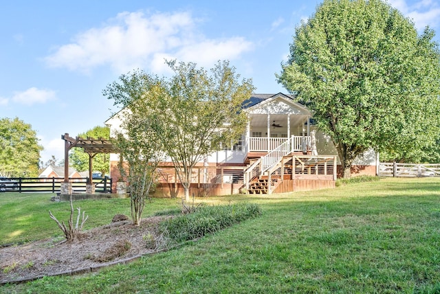 back of property featuring ceiling fan and a lawn