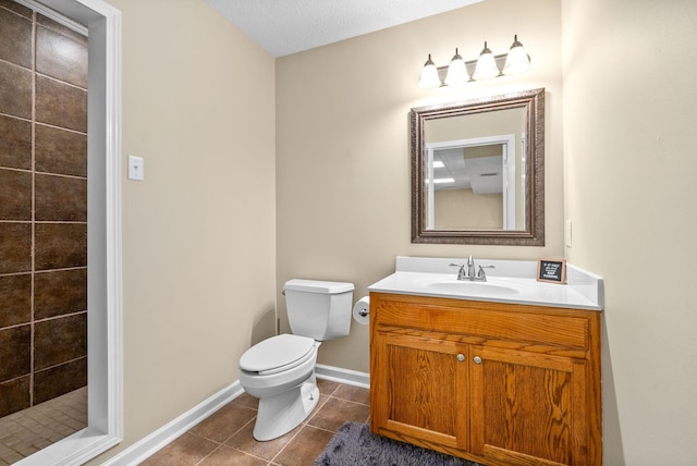 bathroom with tiled shower, vanity, toilet, and tile patterned flooring