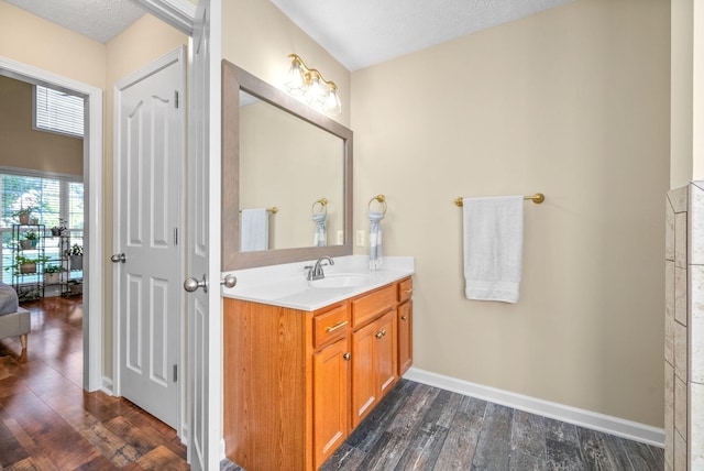 bathroom with hardwood / wood-style flooring, vanity, and a textured ceiling