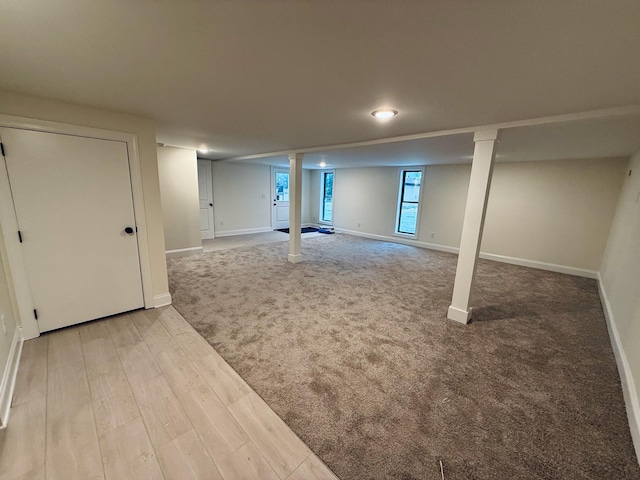 basement featuring carpet flooring, baseboards, and wood finished floors