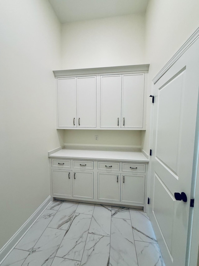 clothes washing area featuring baseboards and marble finish floor