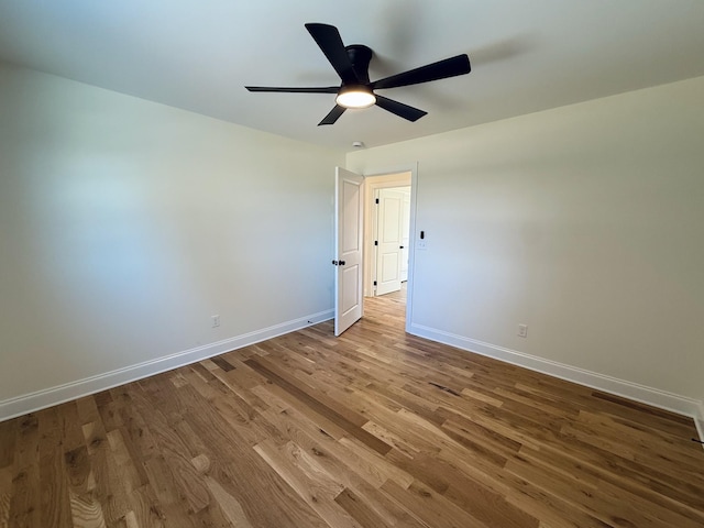 interior space with a ceiling fan, baseboards, and wood finished floors