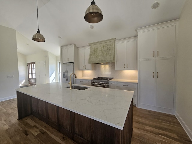 kitchen featuring a sink, a spacious island, dark wood-style floors, appliances with stainless steel finishes, and custom exhaust hood