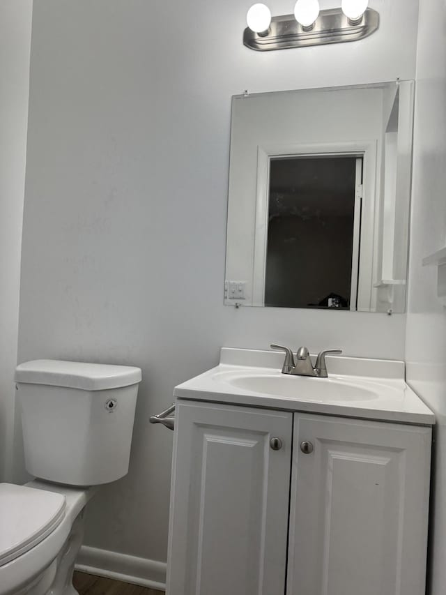 bathroom featuring hardwood / wood-style flooring, vanity, and toilet