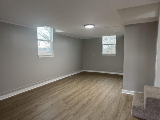 basement with ornamental molding and hardwood / wood-style floors