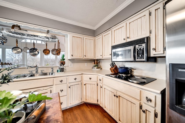 kitchen featuring sink, crown molding, appliances with stainless steel finishes, light hardwood / wood-style floors, and a textured ceiling