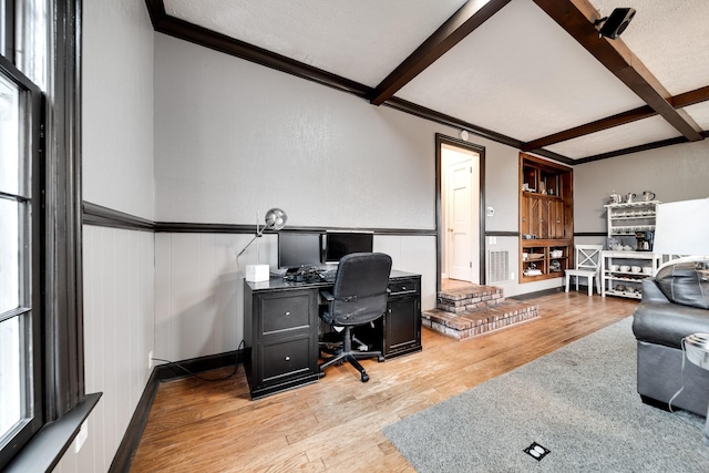 office area featuring crown molding, a textured ceiling, light hardwood / wood-style floors, and beamed ceiling