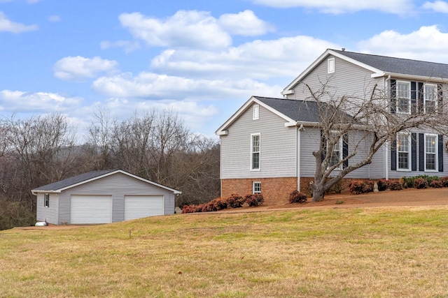 view of side of home featuring a garage, a yard, and an outdoor structure