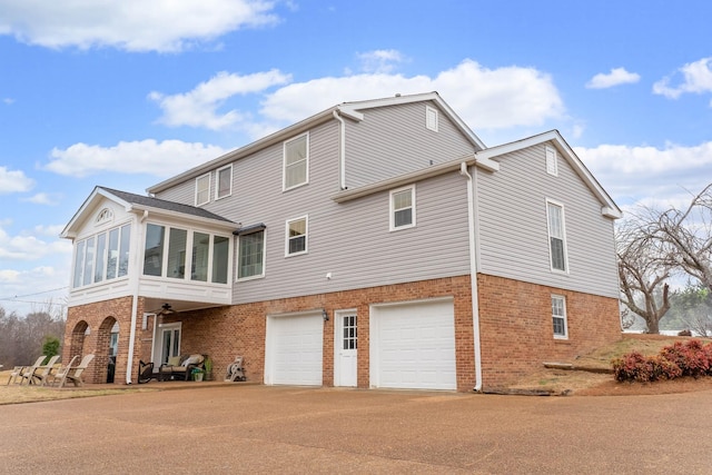 back of house with a garage and a sunroom