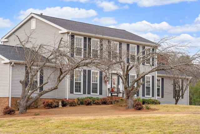 colonial home featuring a front lawn