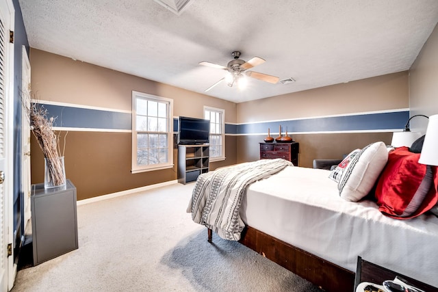 bedroom featuring ceiling fan, a textured ceiling, and carpet