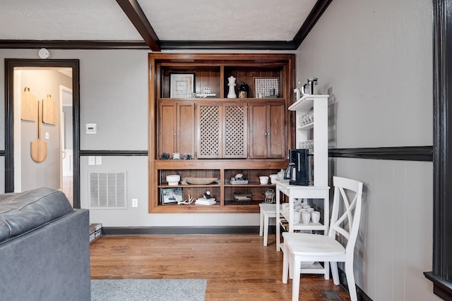 interior space featuring hardwood / wood-style flooring, crown molding, and a textured ceiling