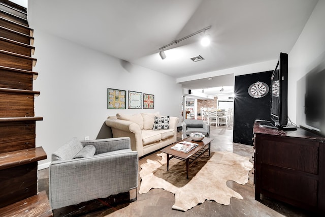 living room with concrete flooring and track lighting