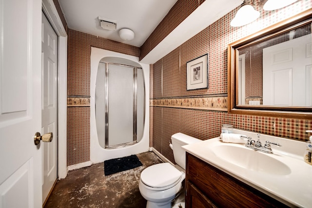 bathroom featuring vanity, toilet, a shower with shower door, and tile walls