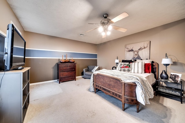 bedroom featuring ceiling fan, carpet floors, and a textured ceiling