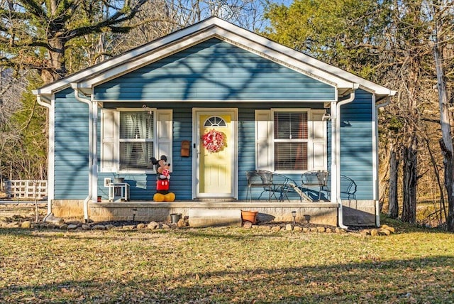 bungalow-style house with a front yard and covered porch