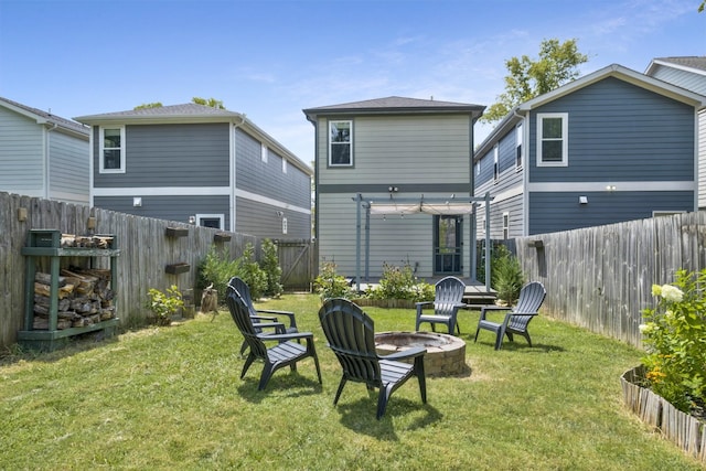 back of house featuring a fire pit and a lawn