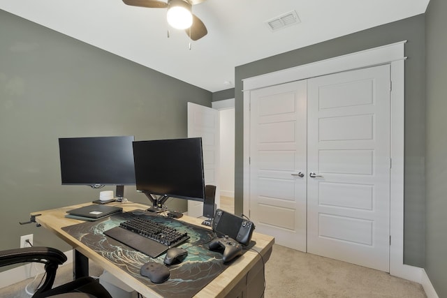 carpeted office space featuring ceiling fan