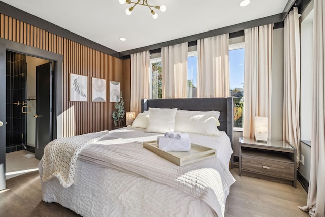 bedroom with hardwood / wood-style flooring and an inviting chandelier