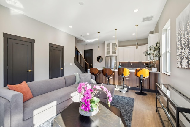 living room featuring bar and light hardwood / wood-style floors