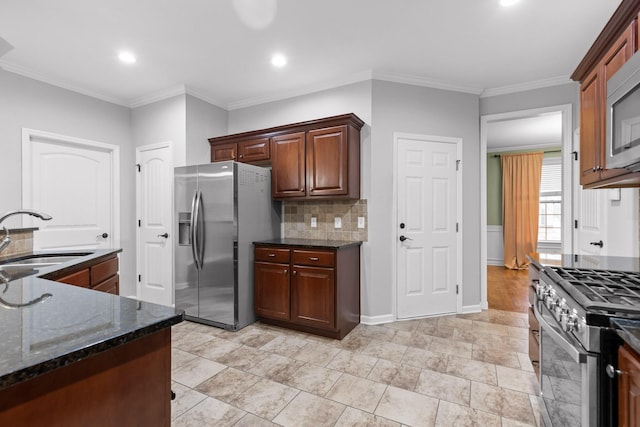 kitchen featuring appliances with stainless steel finishes, tasteful backsplash, sink, dark stone counters, and crown molding