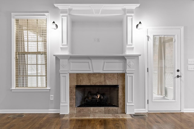 room details featuring wood-type flooring and a tile fireplace