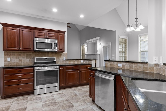 kitchen with vaulted ceiling, appliances with stainless steel finishes, sink, and backsplash