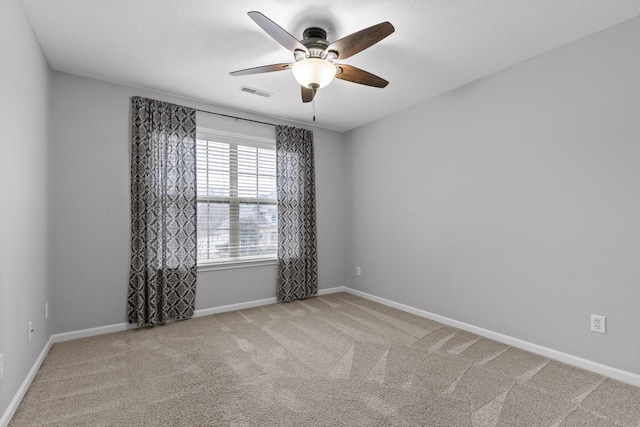 carpeted spare room featuring ceiling fan