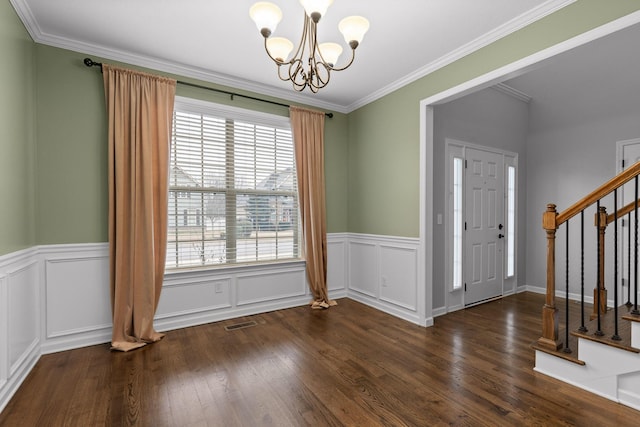 foyer featuring a notable chandelier, dark wood-type flooring, and ornamental molding