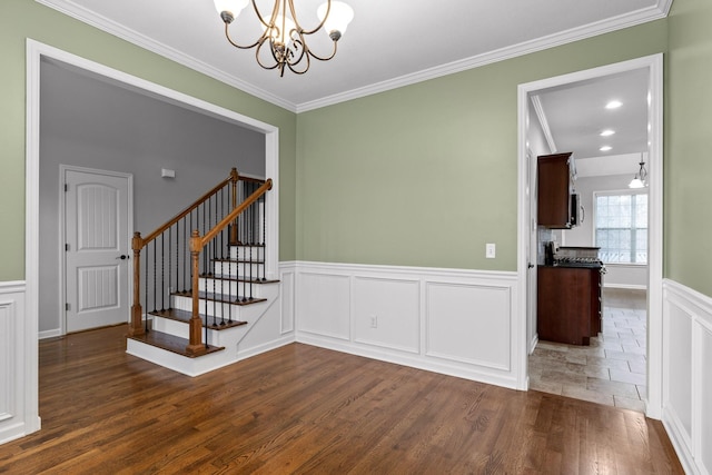 interior space with a notable chandelier, ornamental molding, and dark hardwood / wood-style floors