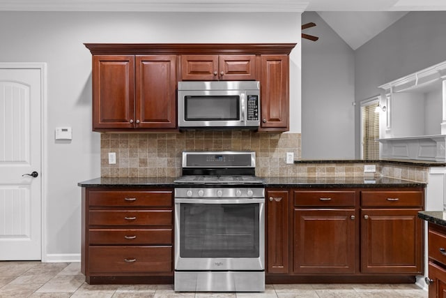 kitchen featuring lofted ceiling, dark stone counters, ceiling fan, stainless steel appliances, and backsplash