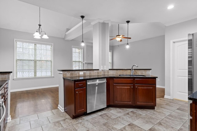 kitchen with vaulted ceiling, pendant lighting, dishwasher, sink, and dark stone counters