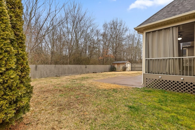 view of yard featuring a storage unit, a sunroom, and a patio area