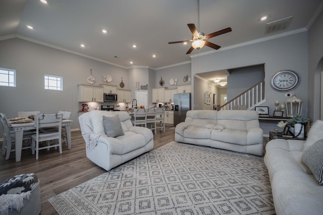 living room featuring vaulted ceiling, sink, ornamental molding, ceiling fan, and light hardwood / wood-style floors