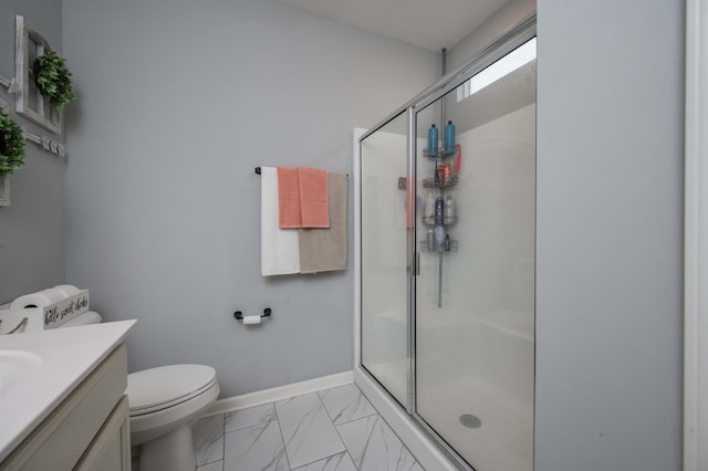 bathroom featuring a shower with door, vanity, and toilet