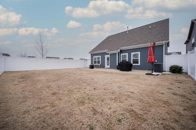 back of property with a patio, a yard, and central AC unit