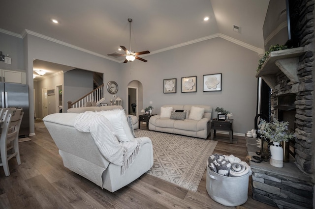 living room featuring hardwood / wood-style floors, crown molding, vaulted ceiling, and ceiling fan