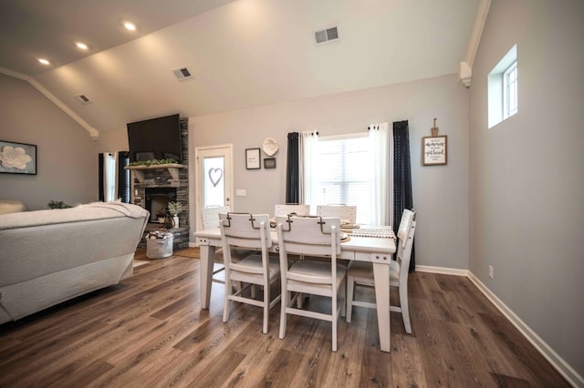 dining area with dark hardwood / wood-style flooring, a fireplace, vaulted ceiling, and ornamental molding