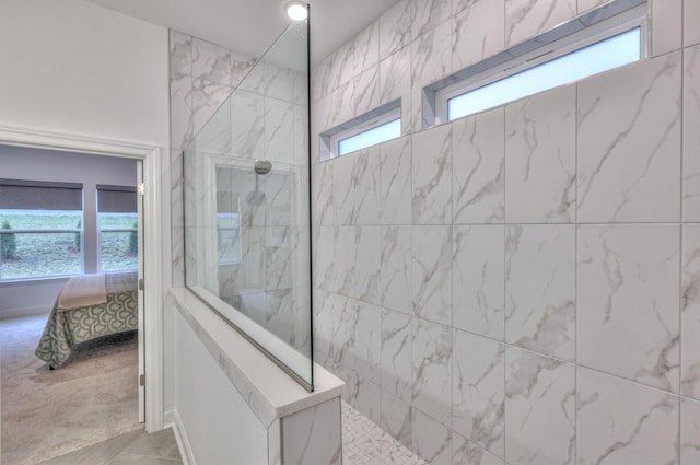 bathroom with a healthy amount of sunlight and tiled shower