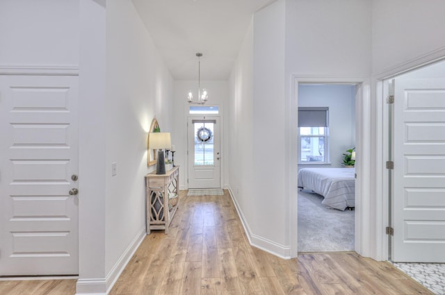 entrance foyer with light hardwood / wood-style floors and a notable chandelier