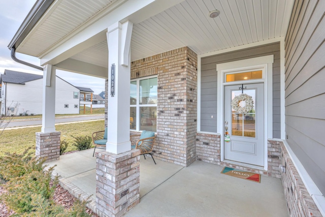 view of exterior entry featuring covered porch