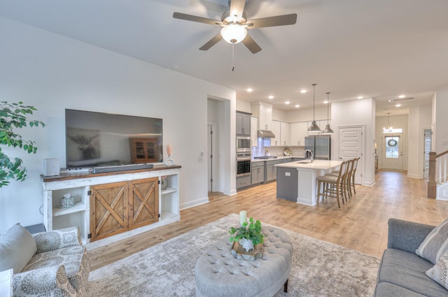 living room featuring light hardwood / wood-style floors and ceiling fan