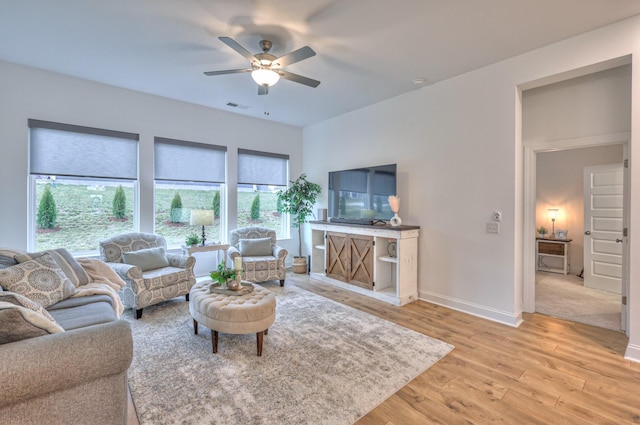 living room featuring ceiling fan and light hardwood / wood-style flooring