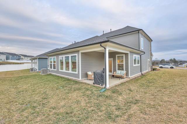 back of house featuring central AC, a yard, and a patio