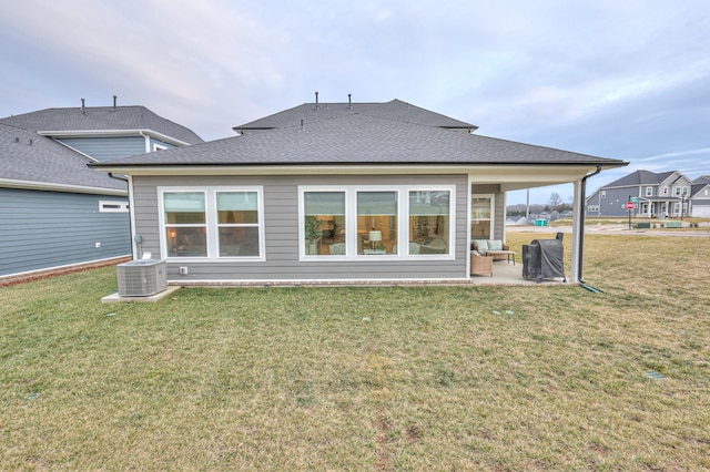 back of house featuring central AC, a patio area, and a lawn